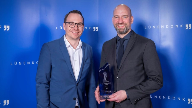 Harald Felling, CEO ]init[, und Mario Zillmann, Partner Lünendonk, bei der Preisverleihung des B2B Service Awards 2023. Harald Felling hält den Award in der Kategorie "Leistung" in den Händen.
