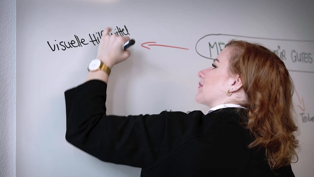 Ein Frau schreib an ein Whiteboard.