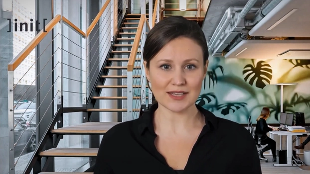 Ein digitaler Avatar führt zu Beginn des Webinars in das Thema ein. Der Avatar ist eine realistisch aussehende Frau vor einem Office-Hintergrund.