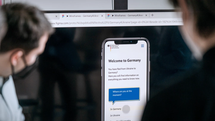 At the digitalization lab for the further development of Germany4Ukraine, two people look at the digital prototype of the G4U app.