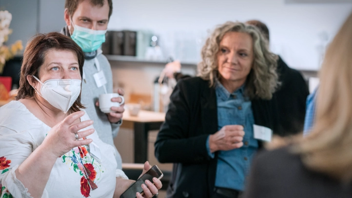 A woman who fled from Ukraine reports on her impressions upon arrival in Germany. Employees of the Federal Ministry of the Interior and ]init[ listen to her attentively.