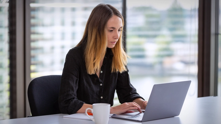 Eine UX-Beraterin analysiert Daten auf ihrem Laptop.