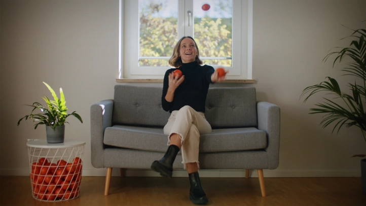Eine Beraterin jongliert mit Bällen auf einem Sofa in der Münchner Niederlassung.