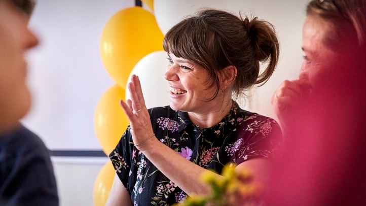 A colleague greets colleagues with a happy smile.