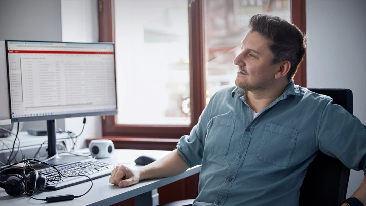 Glücklicher Mann vor seinem Arbeitsplatz