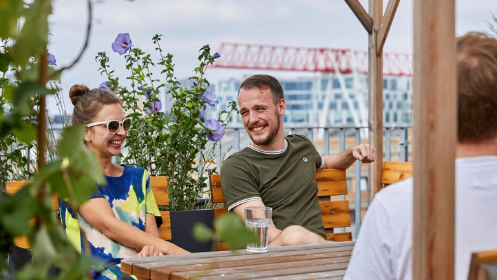 Menschen sitzen auf Dachterrasse