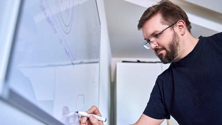 Mensch schreibt auf Tafel