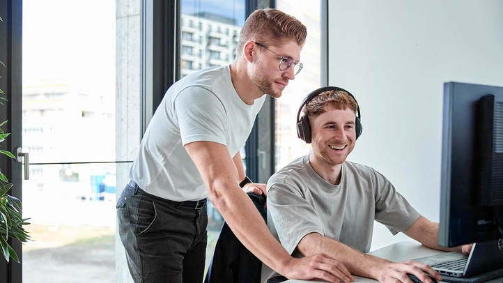 Zwei Menschen arbeiten gemeinsam am Bildschirm