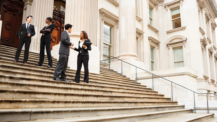 Menschen stehen auf Treppenstufen eines Regierungsgebäudes