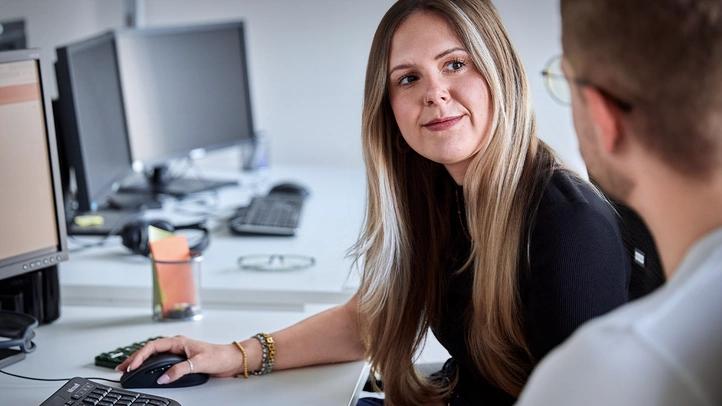 Zwei Menschen vor einem Computer