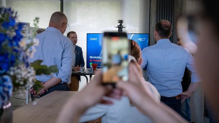 Mit einem Smartphone wird auf einem Workshop ein Foto gemacht. 