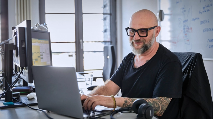 Ein Entwickler sitzt konzentriert vor einem Laptop.