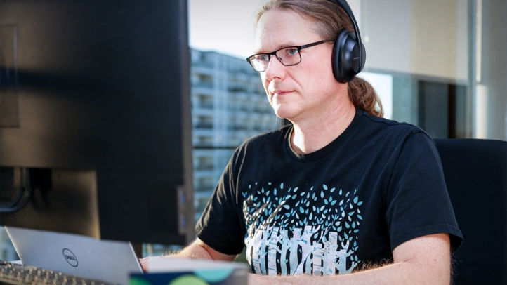 A developer looks intently at a screen and works on code.