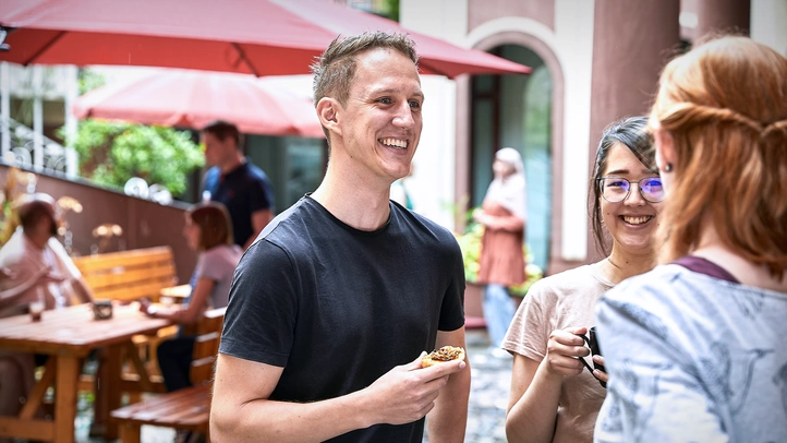 Mitarbeiter:innen verbringen eine Pause im grünen Innenhof des Gebäudes.