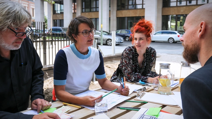 A UX team works on wireframes in the courtyard of the Berlin office.