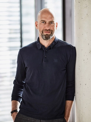 Harald Felling, Chief Executive Officer of ]init[ AG, leans against a concrete column in an office in Berlin.