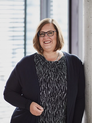 Julia Läkemäker, Chief Operating Officer der ]init[ AG, steht in ihrem Berliner Büro vor einer Fensterfront.