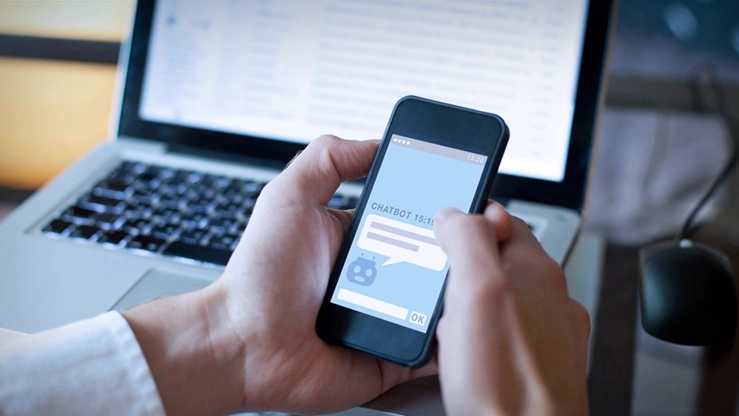 Mann nutzt Smartphone, dass einen Chatbot anzeigt.
