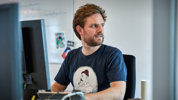 Person arbeitet am PC-Arbeitsplatz in einer Agentur