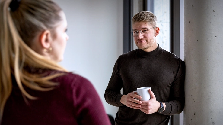 Zwei Kolleg:innen tauschen sich in der Office-Küche aus.