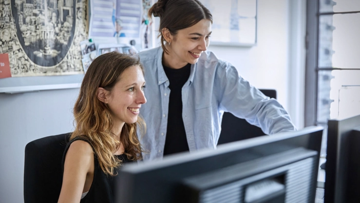 Zwei Mitarbeiterinnen arbeiten gemeinsam im Office.