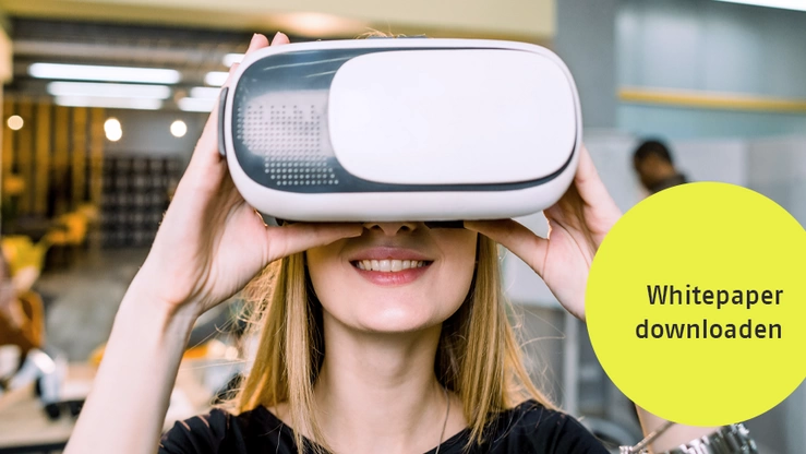 Eine junge Frau hält ein Virtual Reality Headset vor ihr Gesicht.