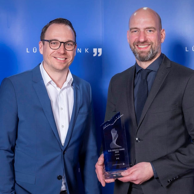 Harald Felling, CEO ]init[, und Mario Zillmann, Partner Lünendonk, bei der Preisverleihung des B2B Service Awards 2023. Harald Felling hält den Award in der Kategorie "Leistung" in den Händen.