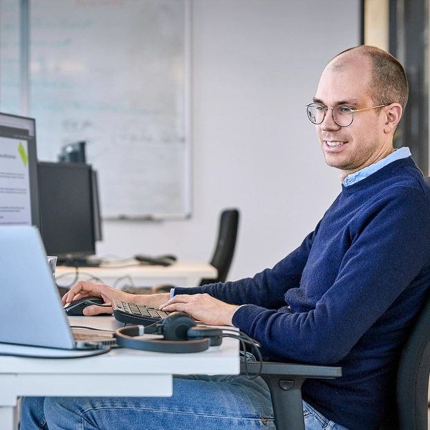 Person arbeitet am PC-Arbeitsplatz