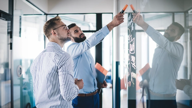 Team an Whiteboard arbeitend