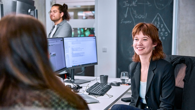 Frau am Arbeitsplatz mit Bildschirmen