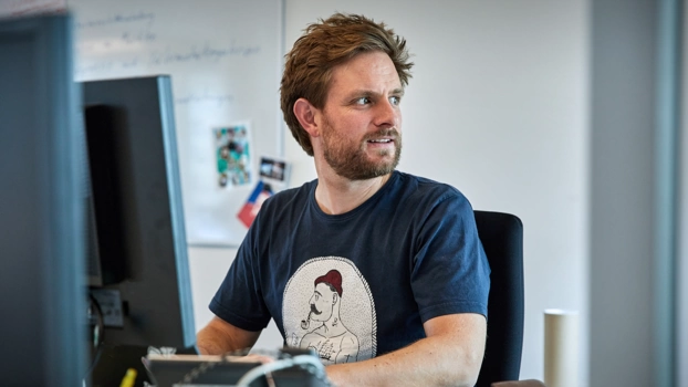 Person arbeitet am PC-Arbeitsplatz in einer Agentur