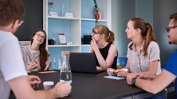 Ein Projektteam berät sich im Besprechungsraum.